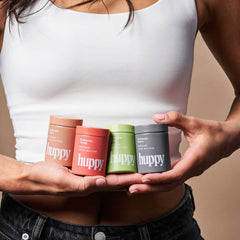 huppy product range display - hands holding four different toothpaste tablet containers in various colours representing different flavour options for personalised oral care