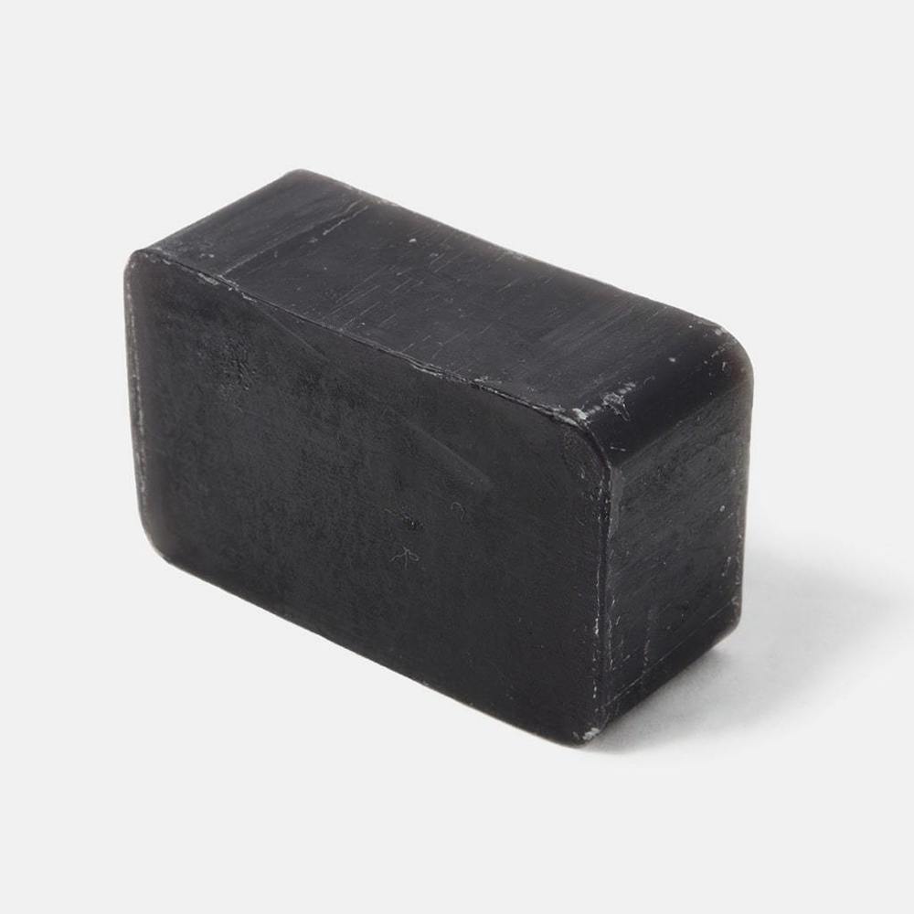 Black rectangular activated charcoal soap bar from Rockwell Razors showing textured surface with natural exfoliating coffee grounds visible