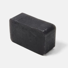 Black rectangular activated charcoal soap bar from Rockwell Razors showing textured surface with natural exfoliating coffee grounds visible