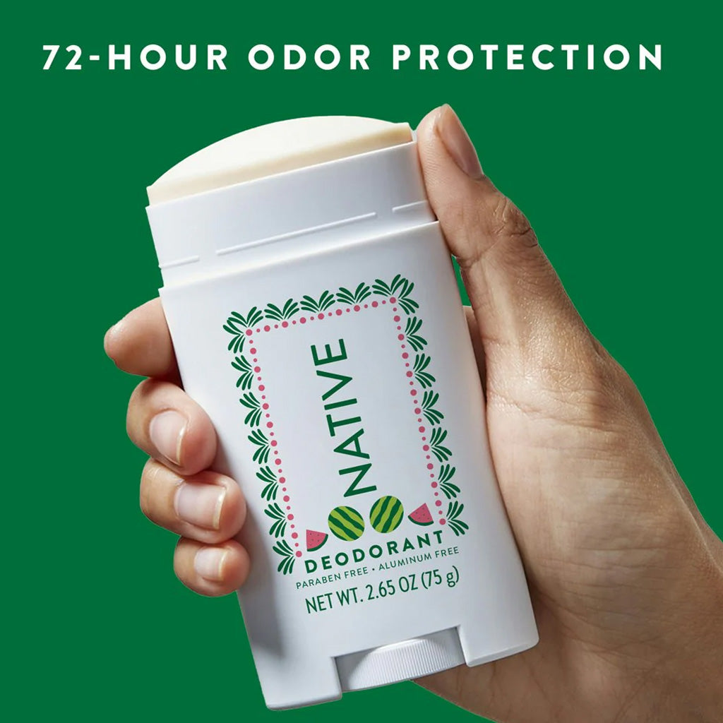 Hand holding a Native deodorant stick with a green background and text about odor protection.