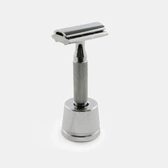 Rockwell safety razor displayed upright in chrome inkwell stand demonstrating elegant presentation and functional storage on bathroom counter.