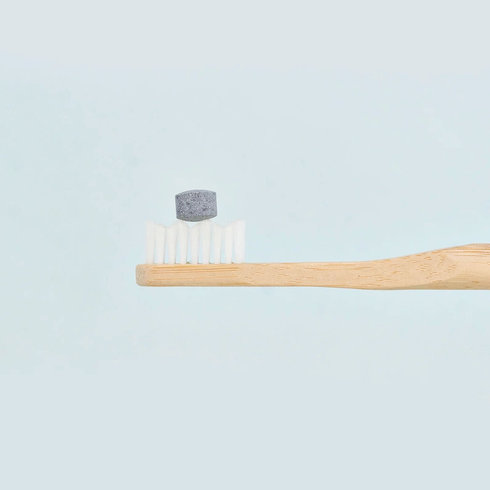 huppy toothpaste tablet on a toothbrush - charcoal mint