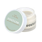 routine Lucy in the Sky deodorant jar open showing cream-coloured natural deodorant texture with sage green lid displaying product name and natural deodorant text