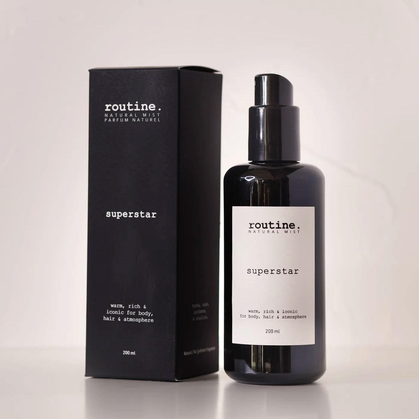 Routine Superstar Natural Mist - black glass bottle with spray pump next to matching black cardboard packaging showing 200ml size - multi-use botanical formula for body, hair and atmosphere
